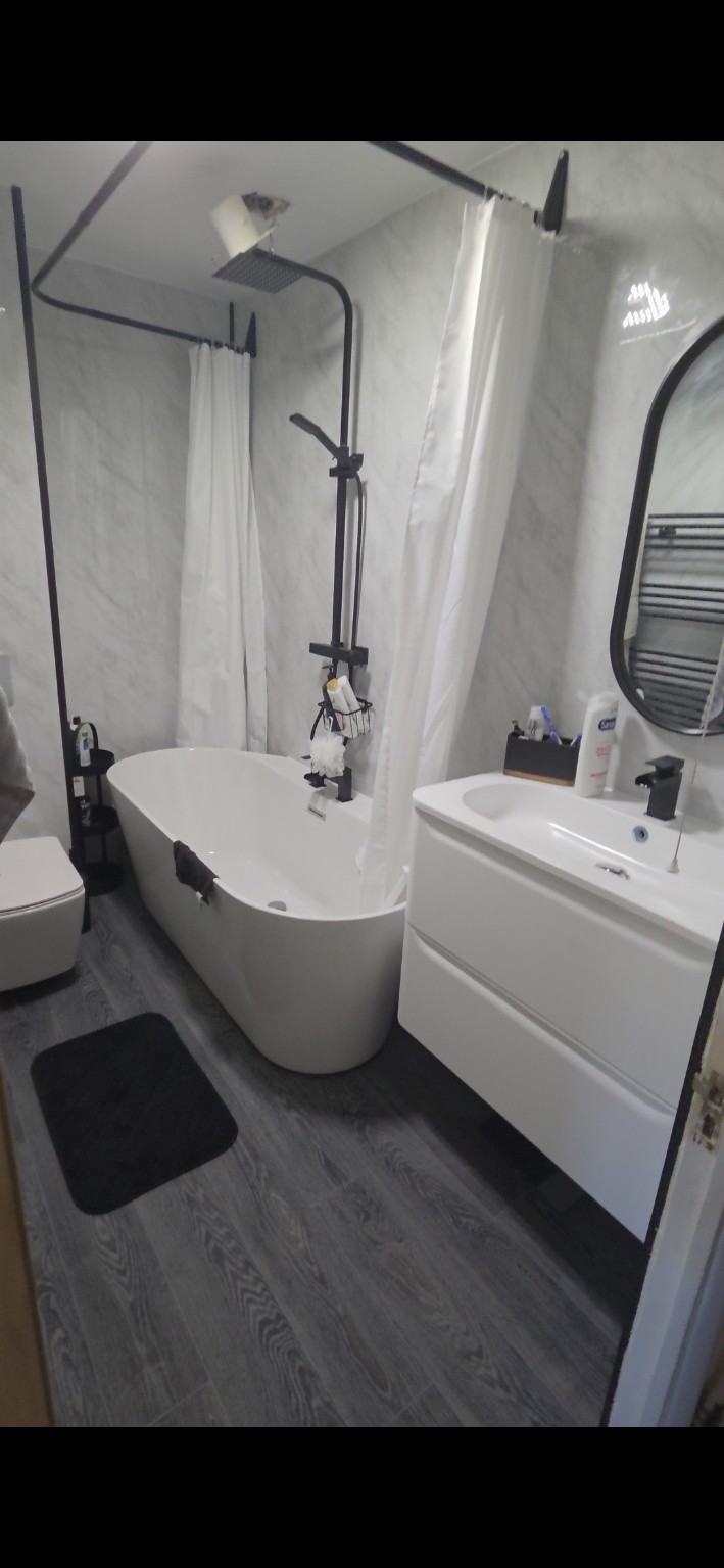 Bathroom installation with freestanding bath and black fittings